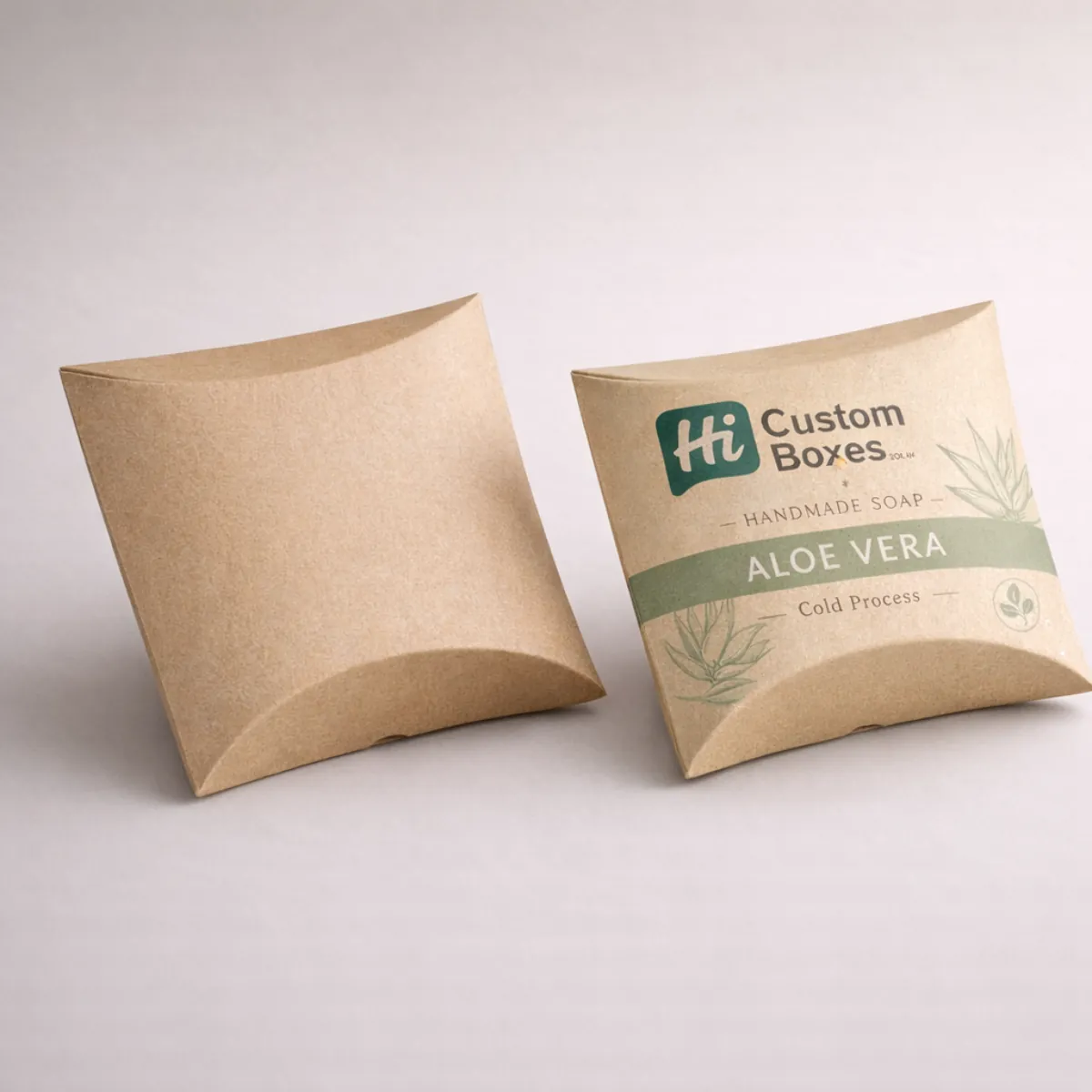Two curved kraft paper pillow boxes, one featuring an 